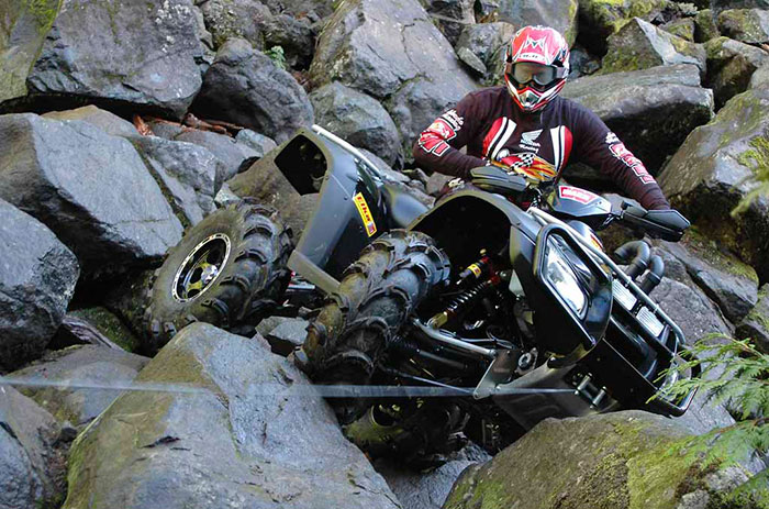 Quad effectuant une manœuvre de treuillage sur un terrain accidenté